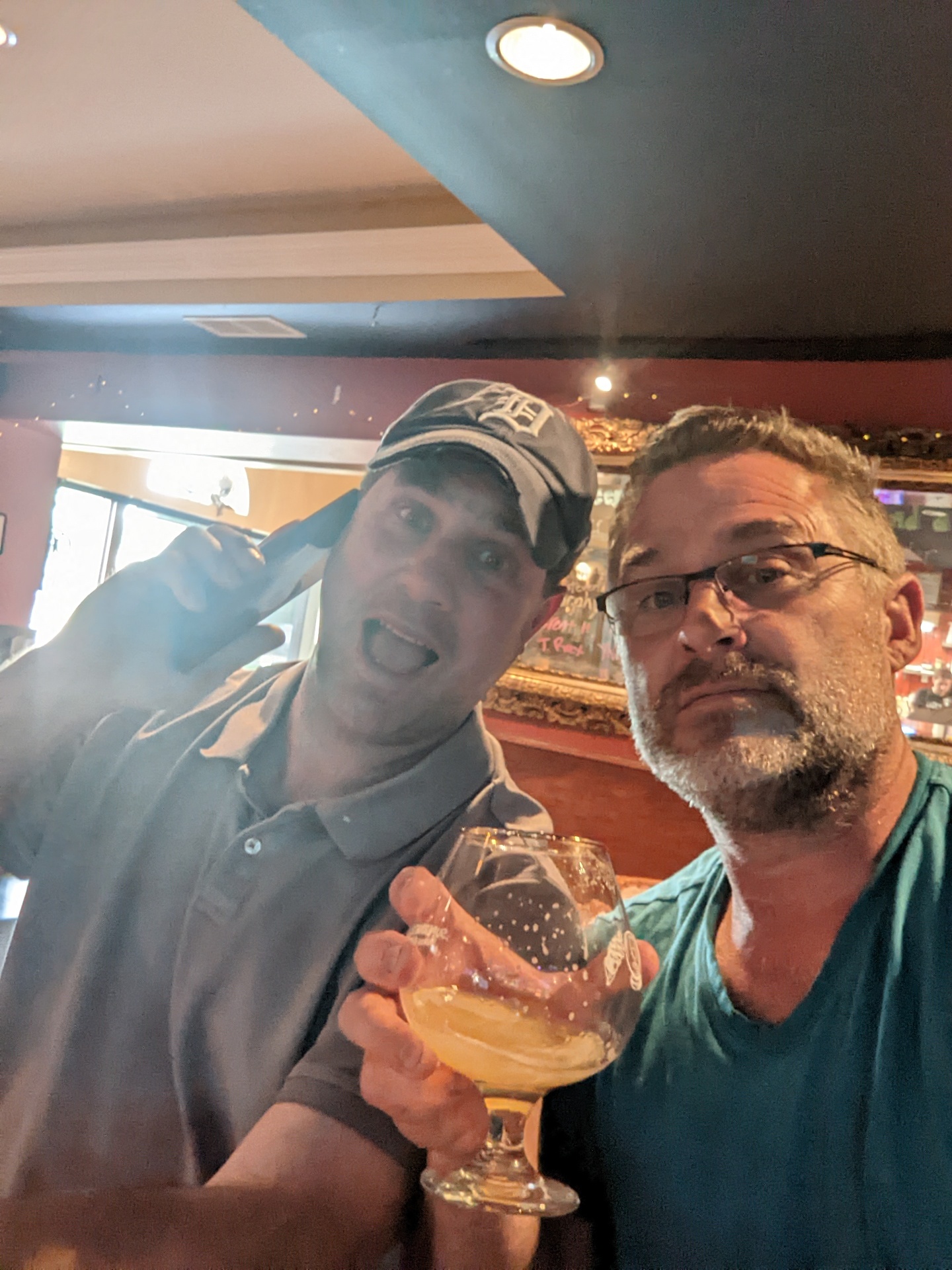 Russ (left, in a Detroit Tigers cap, phone to his ear) and Todd (right, in glasses) sharing a beer at a bar